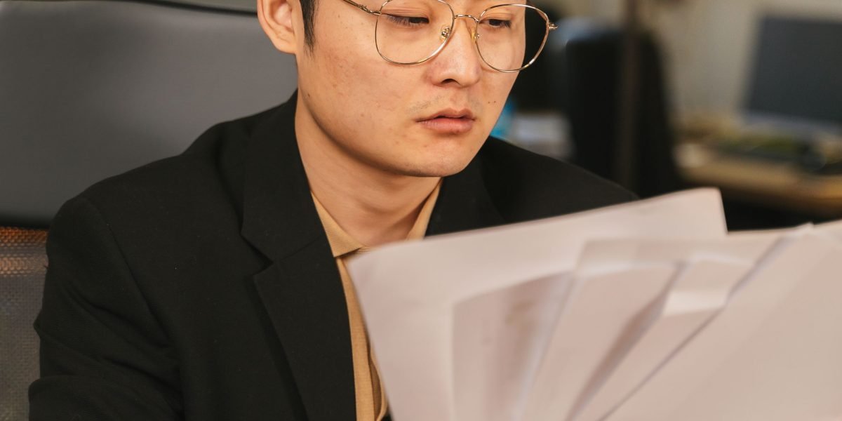 A focused professional carefully reviewing documents, symbolizing the human oversight needed for AI-generated code.