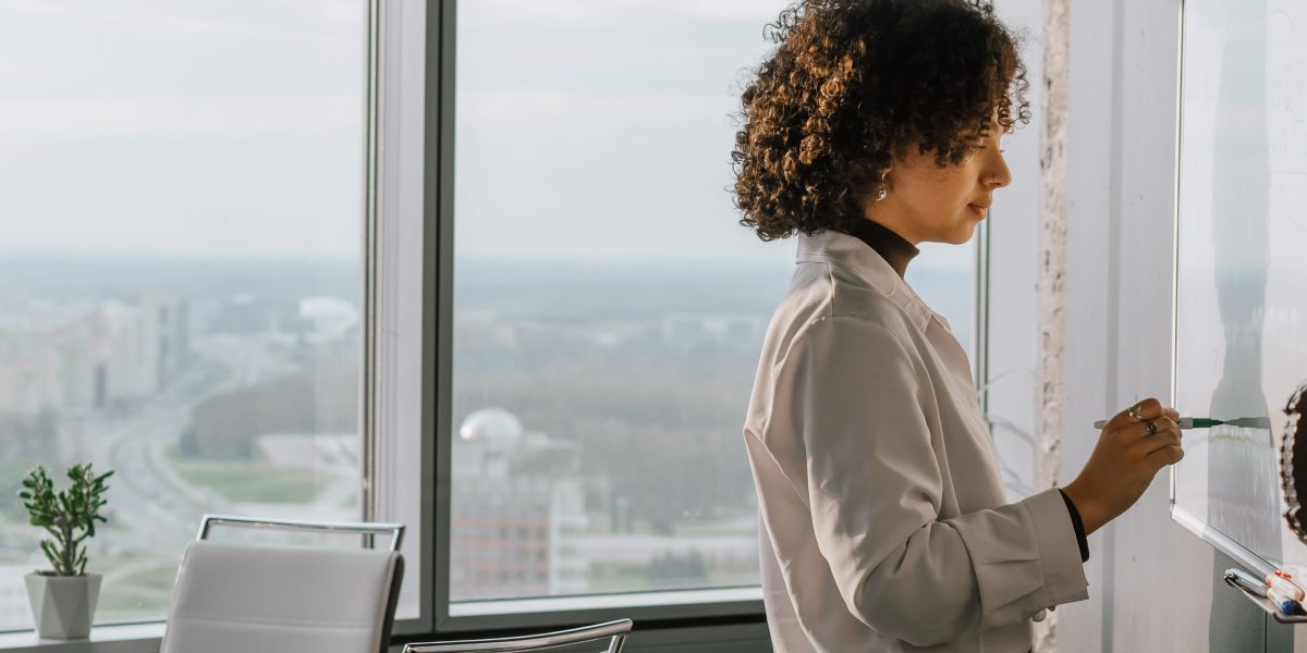 A person writing on a whiteboard, reflecting on complex challenges and strategizing solutions in a fast-changing tech landscape.