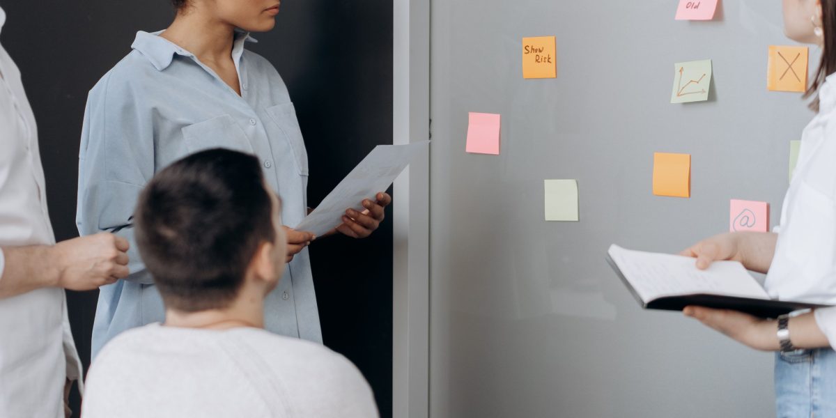 A team collaborates on a whiteboard, strategizing how to overcome complex technical integration issues.