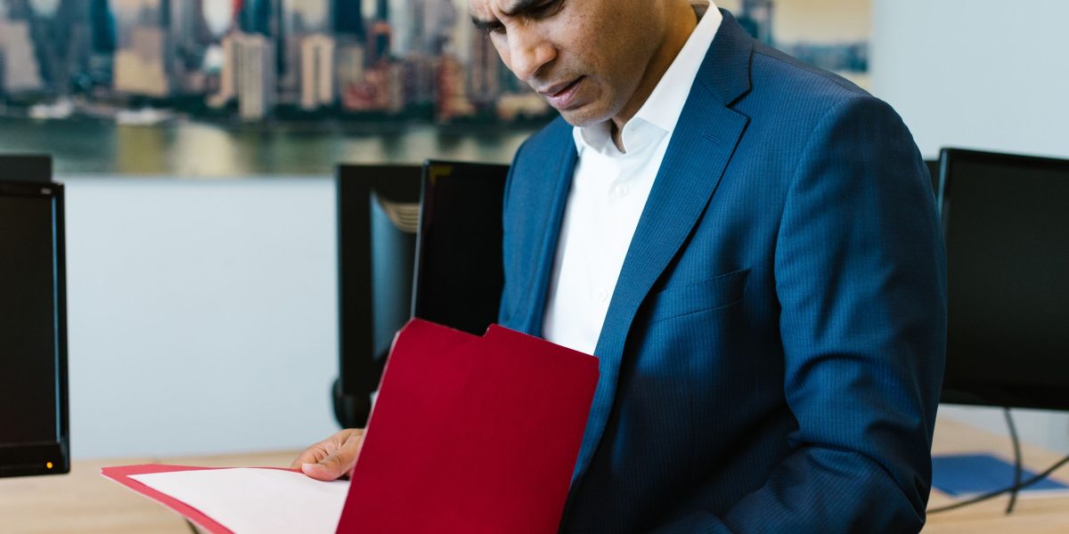 A person diligently reviews documents, assessing potential risks before making a significant career decision.