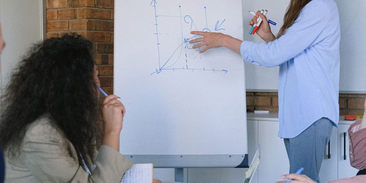 A leader uses a whiteboard to explain a new process or roadmap, guiding their team through a strategic transition.