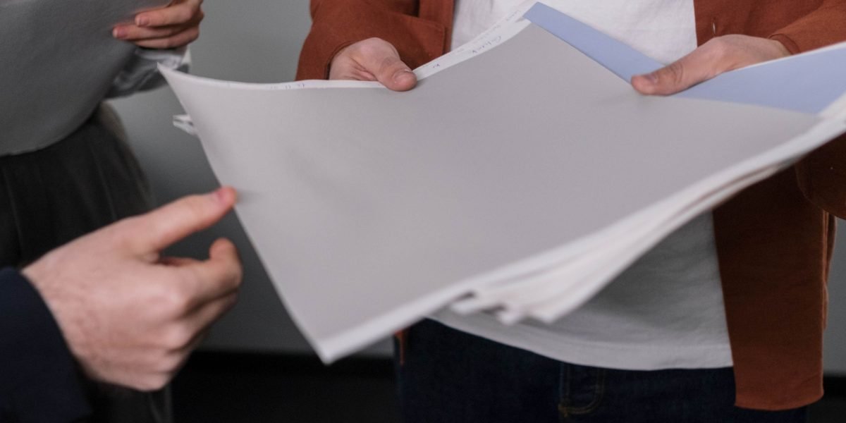 A professional group in a formal meeting, intently reviewing documents related to security and compliance protocols.