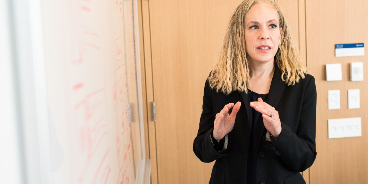 A professional presenting insights or strategies to a group in a modern office setting.