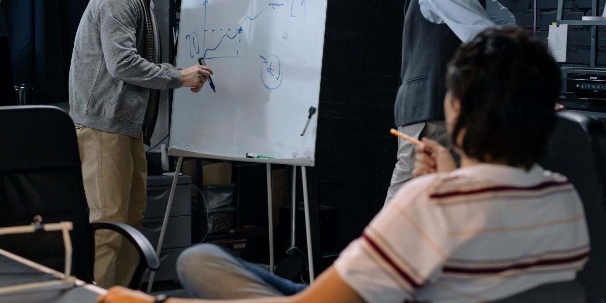 A diverse team collaborating actively around a whiteboard, brainstorming and solving complex problems together.